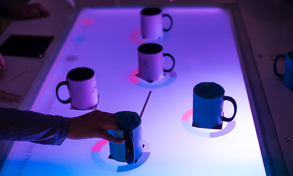 Coffee mugs on a glass table in Wegmans Hall are transformed into an AR classroom exercise that simulates a sprawling, real-life chemical plant.