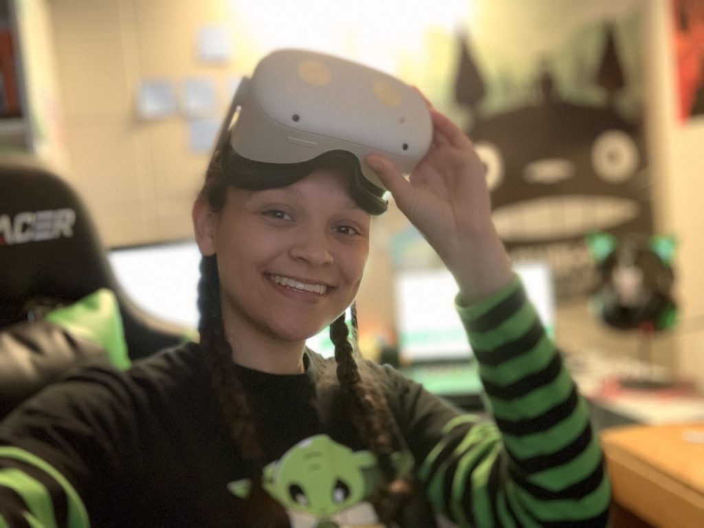 Photo of the author of the article, a young woman, with a virtual reality headset resting on top of her head