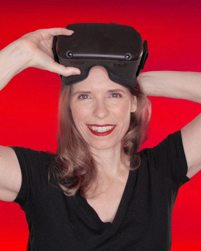 speaker Deirdre Lyons wearing a VR headset and smiling. 