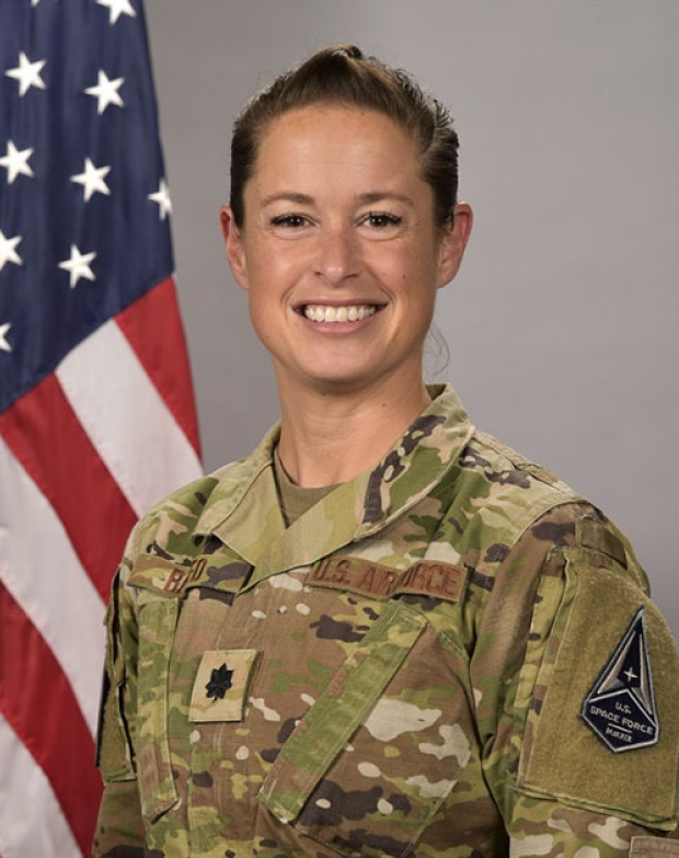 speaker lieutenant colonel Stephanie Raffo standing in front of an American flag. 