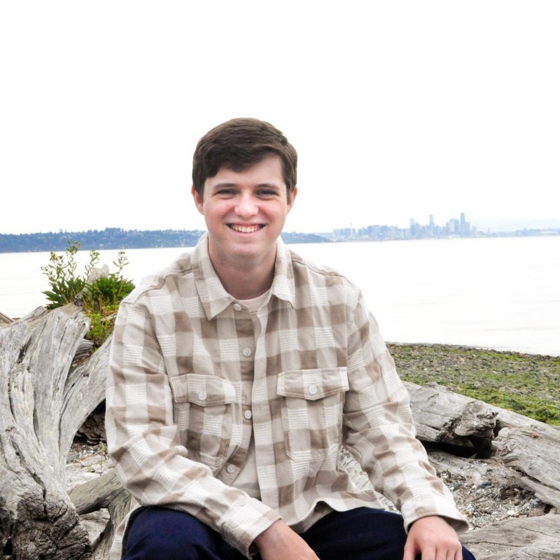 Miles Vilke sitting and smiling near the water