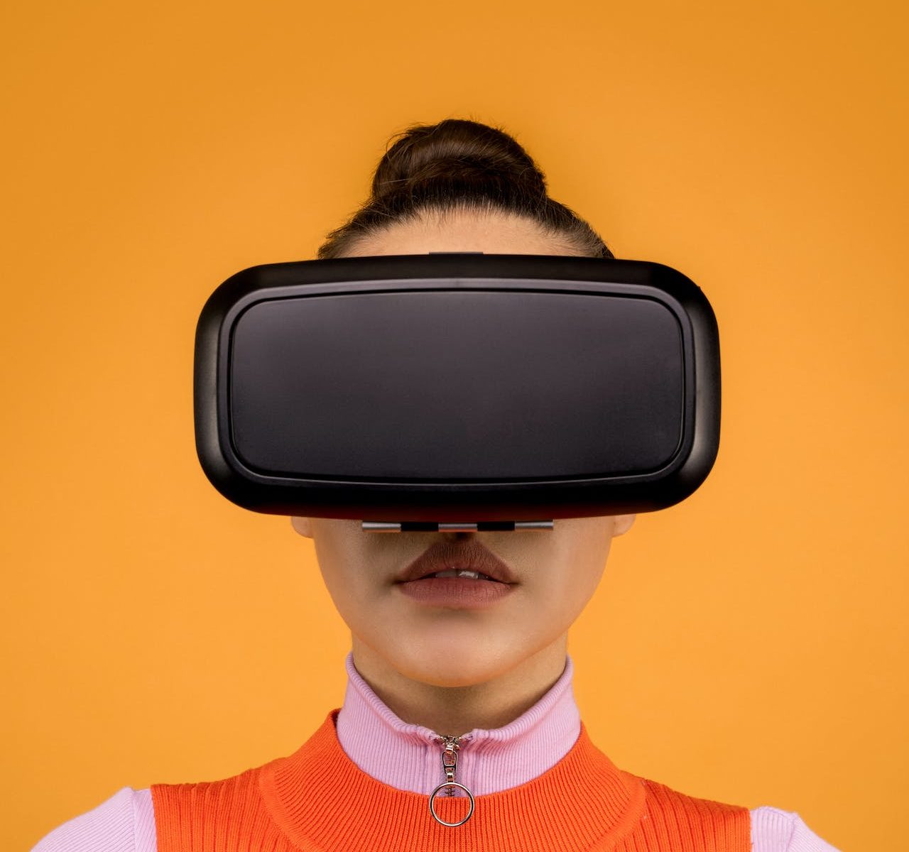 Person in a virtual reality headset in front of a vibrant yellow background.